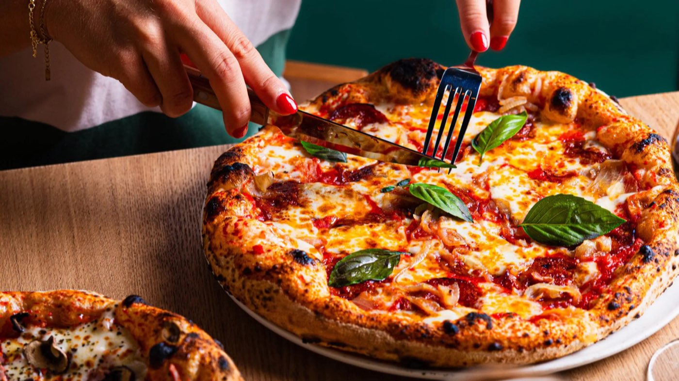 Une pizza margherita servie sur une planche en bois
