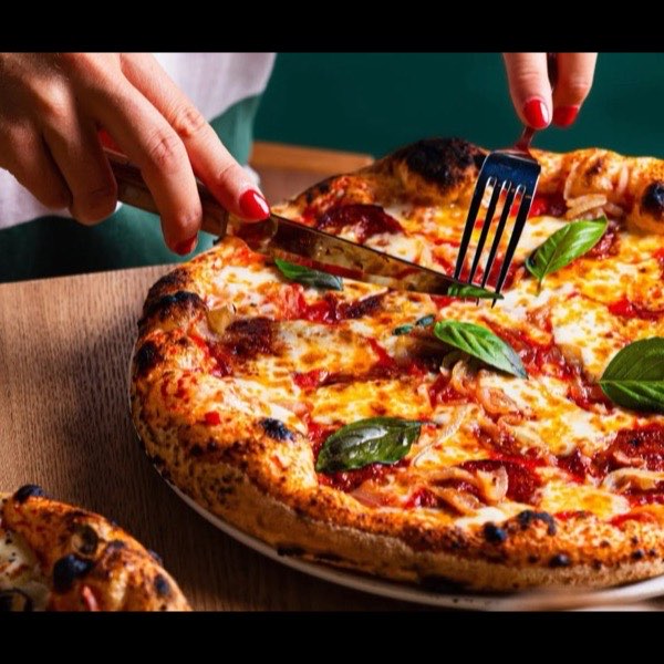 Une pizza margherita partagée à table