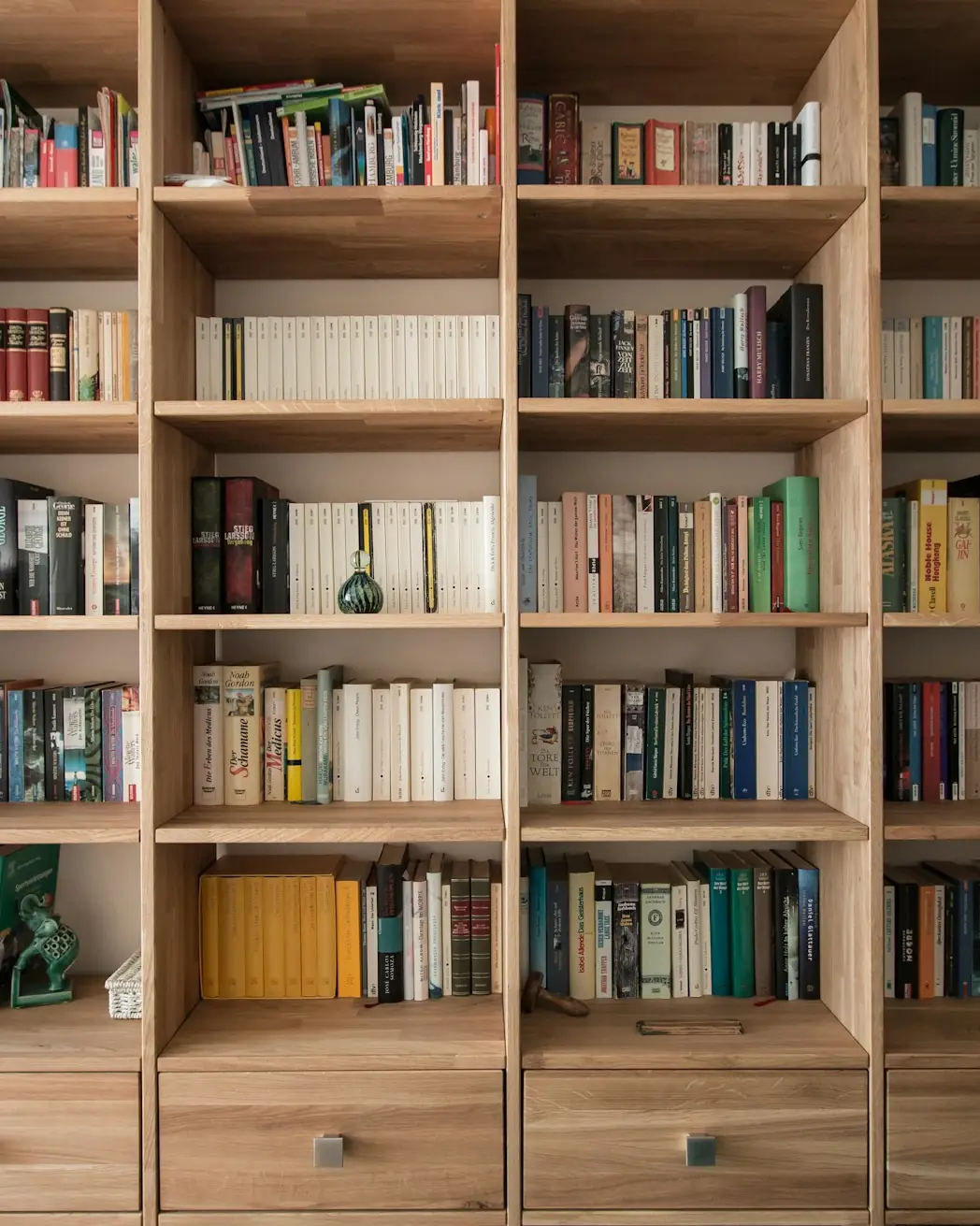 Grande bibliothèque en chêne clair sur mesure, remplie de livres