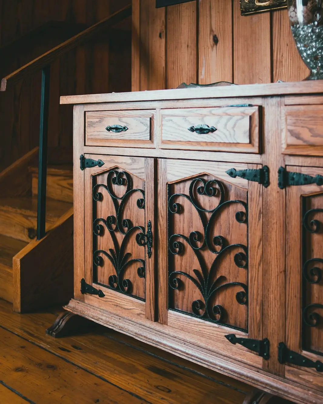 Buffet ancien en bois sculpté avec des ferrures noires décoratives sur les portes
