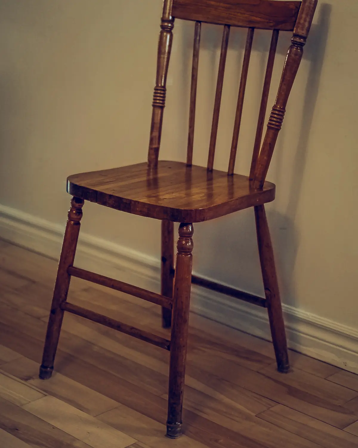Chaise en bois à dossier à barreaux tournés, dans une pièce au parquet ancien