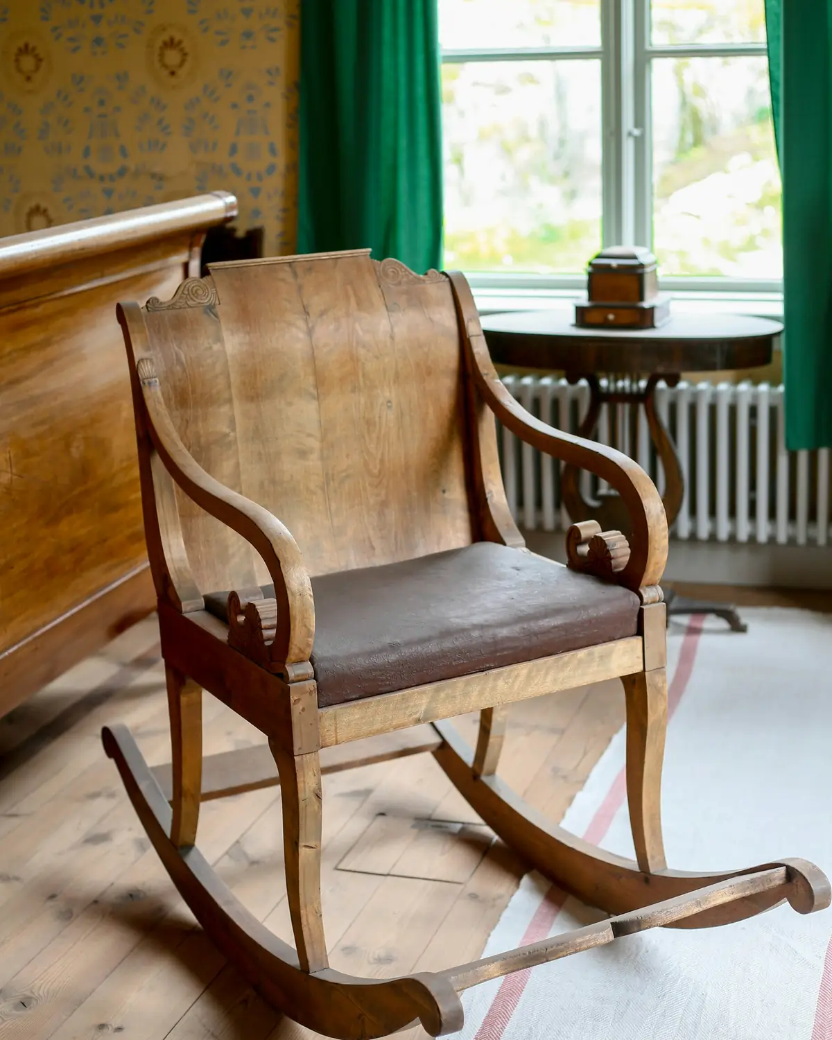 Fauteuil à bascule ancien en bois courbé avec une assise en cuir brun