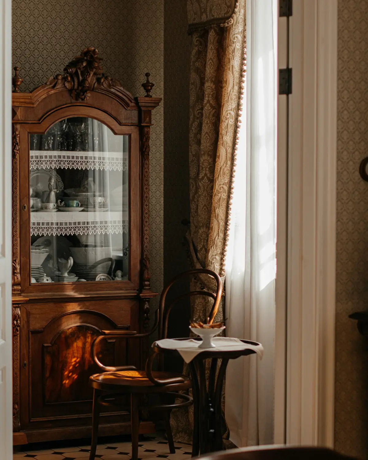 Vaisselier ancien en merisier à portes vitrées, dans une salle à manger